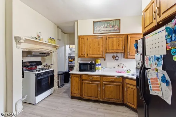 a kitchen with stainless steel appliances a stove a refrigerator cabinets and a dining table
