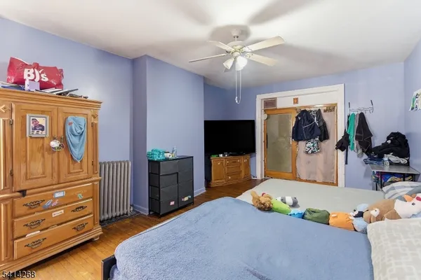 a bedroom with a bed and a flat tv screen on the dresser