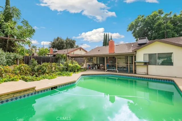 a front view of a house with swimming pool having outdoor seating