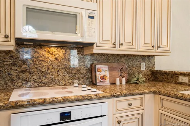 a view of a dining room and livingroom with furniture wooden floor a chandelier