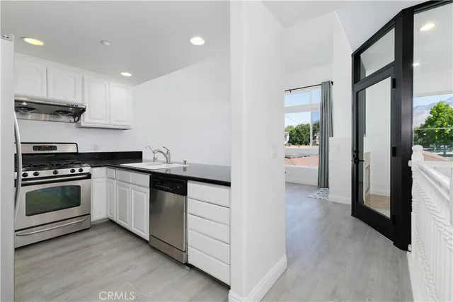 a kitchen with stainless steel appliances kitchen island granite countertop a stove and a refrigerator