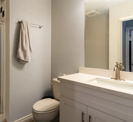 a bathroom with a sink vanity mirror and toilet
