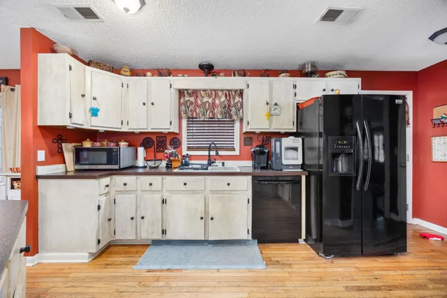a kitchen with stainless steel appliances a stove refrigerator and cabinets