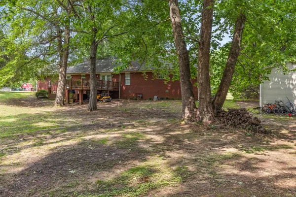 a view of a barn in the yard with large trees