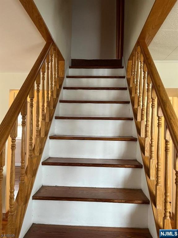 24 Stony Hill Road Clifton, NJ 07013 - Photo 9 of 17 a view of staircase with lots of frames on wall