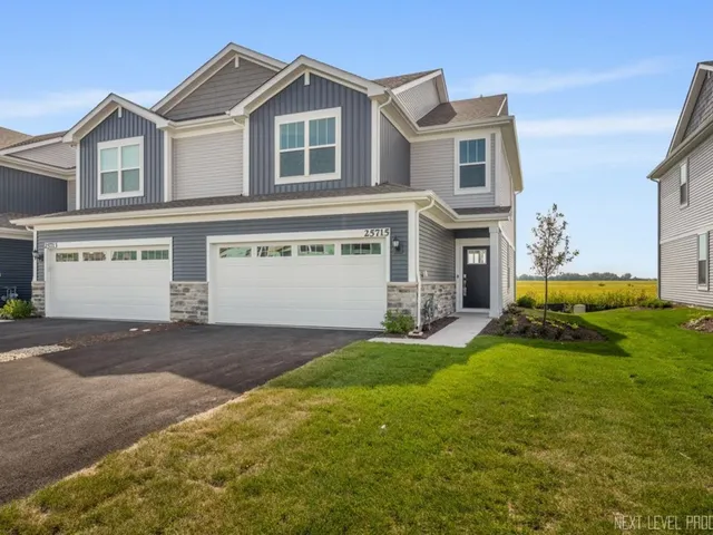 a front view of a house with a yard and garage