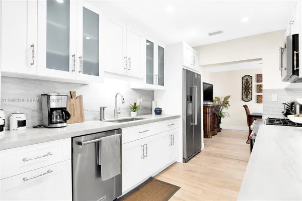 a kitchen with stainless steel appliances kitchen island granite countertop a refrigerator and cabinets