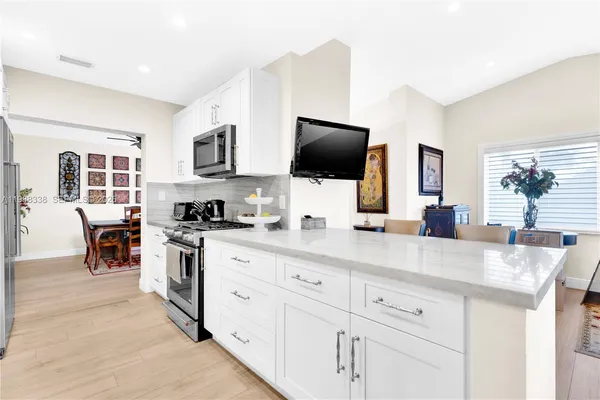 a kitchen with stainless steel appliances white cabinets a sink and a stove