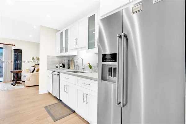 a kitchen with stainless steel appliances a refrigerator sink and cabinets