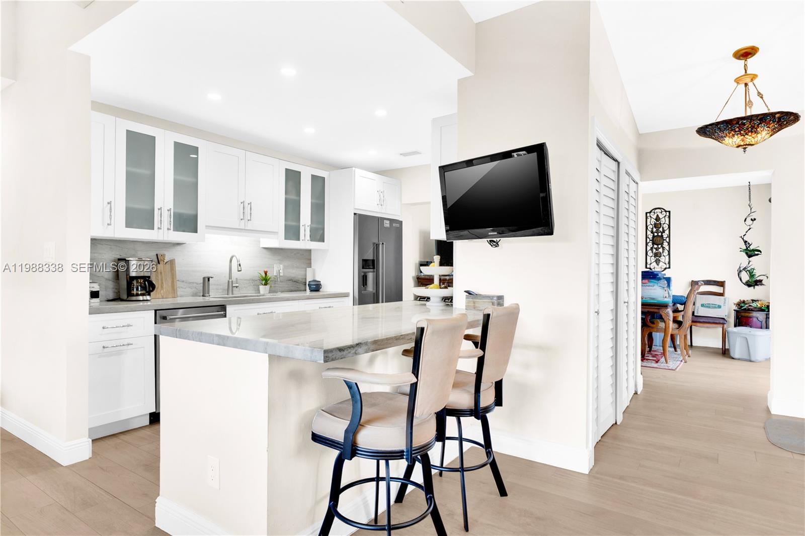 10909 Southwest 113th Place, Unit 68A Miami, FL 33176 - Photo 7 of 37 a kitchen with stainless steel appliances kitchen island granite countertop a stove a sink a dining table and chairs
