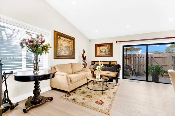 a living room with furniture and floor to ceiling window