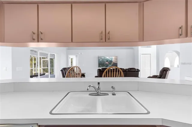 a kitchen with stainless steel appliances granite countertop a sink a stove a washer dryer and cabinets