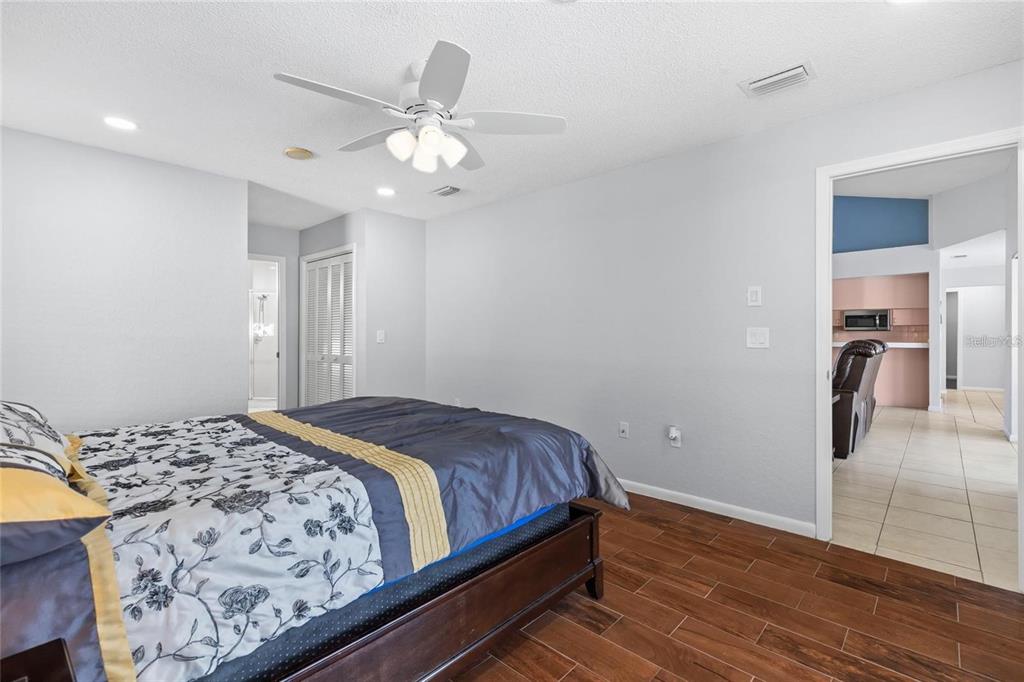 10446 Baylor Drive Spring Hill, FL 34608 - Photo 17 of 32 a bedroom with a large bed and a chandelier