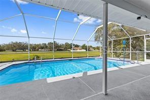 10446 Baylor Drive Spring Hill, FL 34608 - Photo 30 of 32 a view of a swimming pool with lawn chairs and plants
