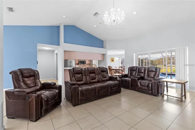 a living room with furniture a chandelier and a dining table
