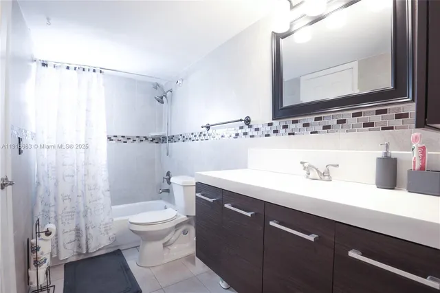 a bathroom with a double vanity sink toilet and mirror