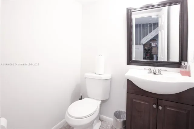 a bathroom with a toilet a sink and mirror