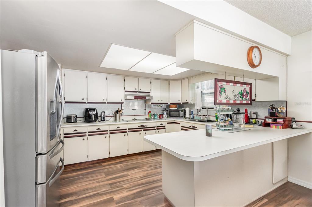 6476 Eve Street St. Cloud, FL 34771 - Photo 10 of 25 a kitchen with a sink a stove cabinets and refrigerator