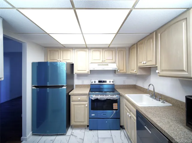 a kitchen with a sink a refrigerator and cabinets