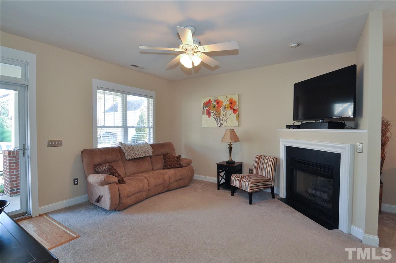 10748 Cokesbury Lane Raleigh, NC 27614 - Photo 3 of 16 a living room with furniture a flat screen tv and a fireplace