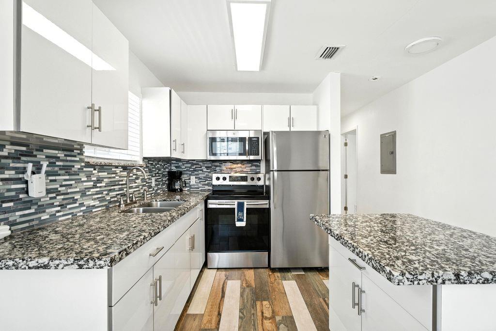 343 Van Buren Street, Unit 8 Hollywood, FL 33019 - Photo 3 of 8 a kitchen with kitchen island a counter top space a sink stainless steel appliances and cabinets