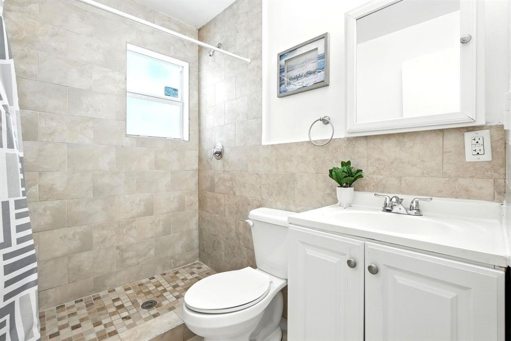 343 Van Buren Street, Unit 8 Hollywood, FL 33019 - Photo 7 of 8 a bathroom with a sink a toilet and shower