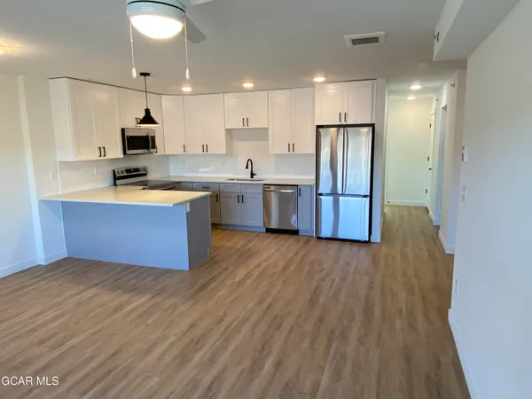 a kitchen with stainless steel appliances a refrigerator and a stove top oven