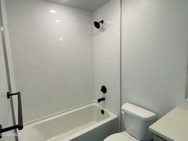 a white toilet sitting next to a bath tub