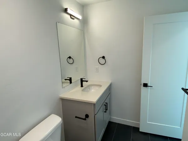 a bathroom with a sink a toilet and a mirror