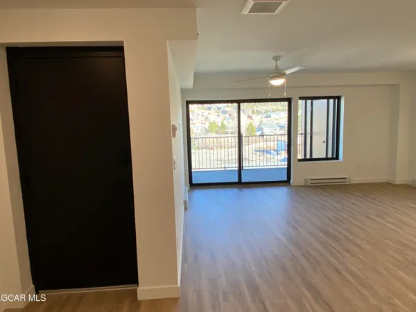 an empty room with wooden floor and windows