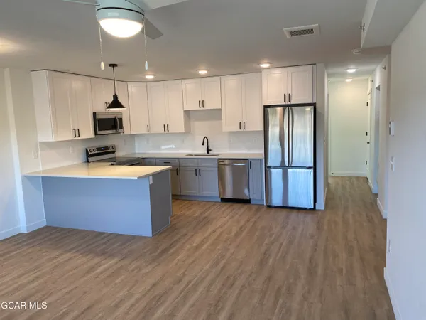 a kitchen with stainless steel appliances granite countertop a stove a sink and a refrigerator