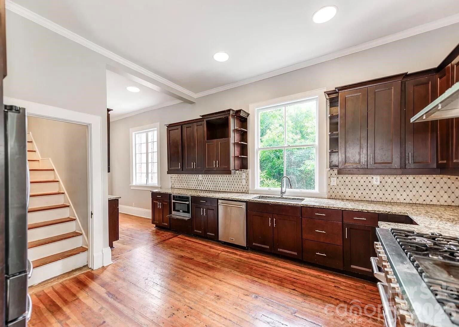 128 West End Street Chester, SC 29706 - Photo 12 of 40 a kitchen with stainless steel appliances granite countertop wooden floors a stove and a sink