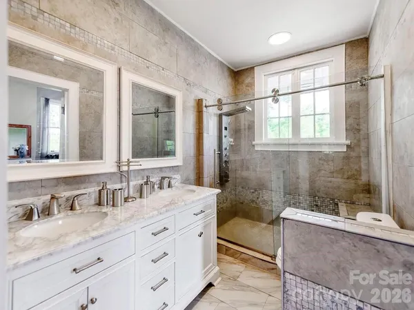 a bathroom with a granite countertop sink mirror and a bathtub