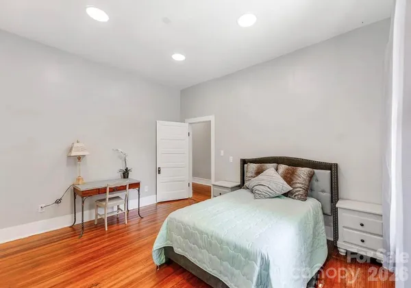 a bedroom with a bed and wooden floor