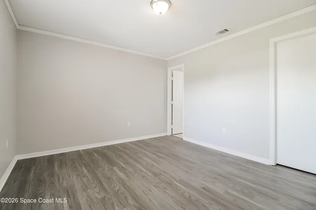 a view of an empty room with wooden floor