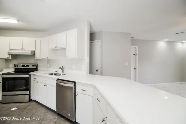 a kitchen with a stove sink and cabinets