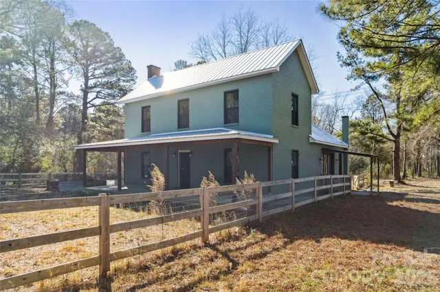 a view of a house with backyard and a tree