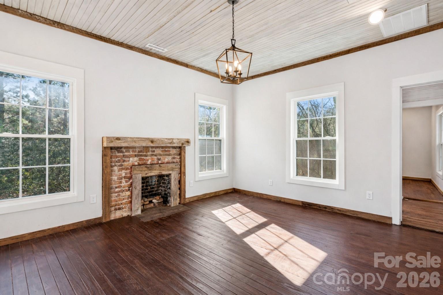 10799 Poplar Tent Road Huntersville, NC 28078 - Photo 33 of 46 a view of an empty room with wooden floor fireplace and a window