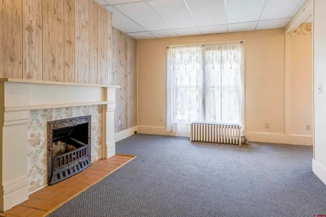 a view of an empty room with a fireplace and a window