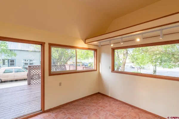 a view of empty room with window and wooden floor