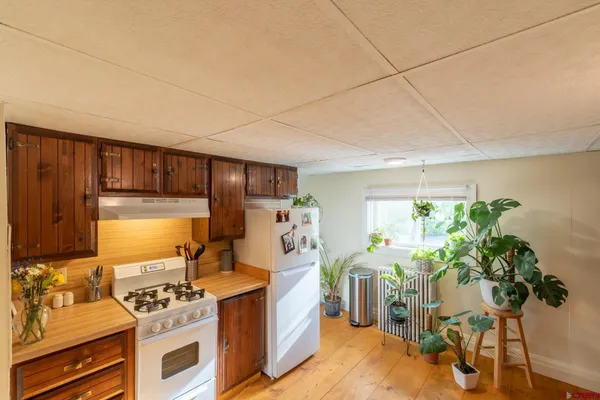 a kitchen with stainless steel appliances a stove a chimney a sink and cabinets