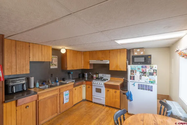 a kitchen with a sink cabinets and wooden floor