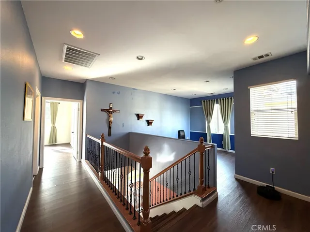 a view of hallway with wooden floor and windows