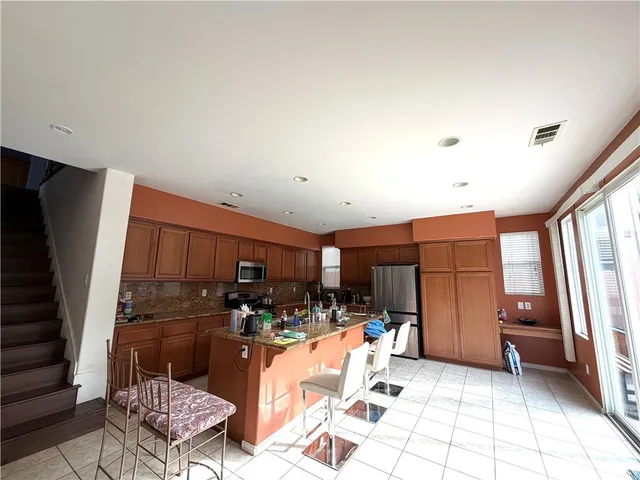 a kitchen with stainless steel appliances a refrigerator and a stove top oven