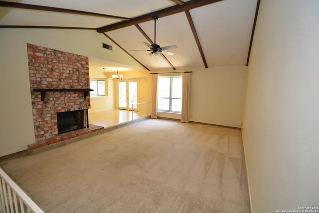 a view of empty room with fireplace and windows