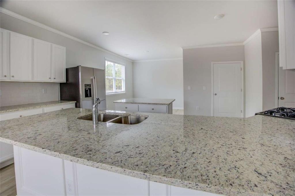 1007 Towne Circle Social Circle, GA 30025 - Photo 19 of 38 a kitchen with a granite countertop sink and cabinets