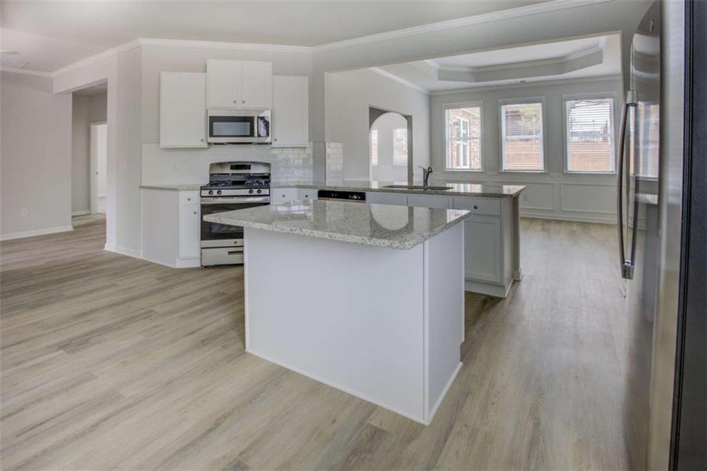1007 Towne Circle Social Circle, GA 30025 - Photo 21 of 38 a kitchen with stainless steel appliances granite countertop a sink stove and refrigerator