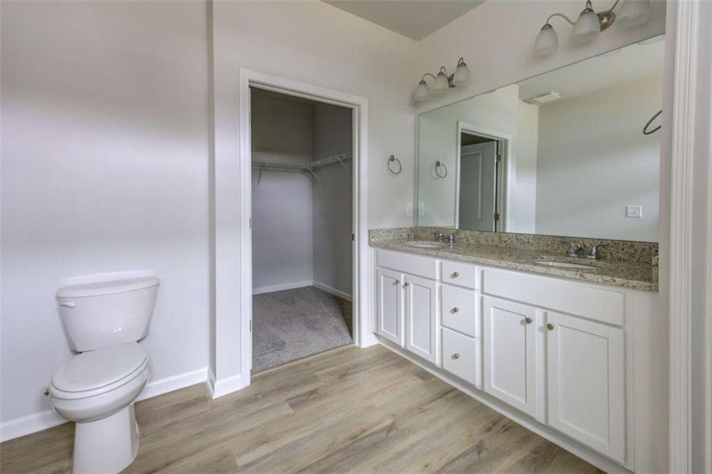 1007 Towne Circle Social Circle, GA 30025 - Photo 31 of 38 a spacious bathroom with a granite countertop toilet sink and mirror