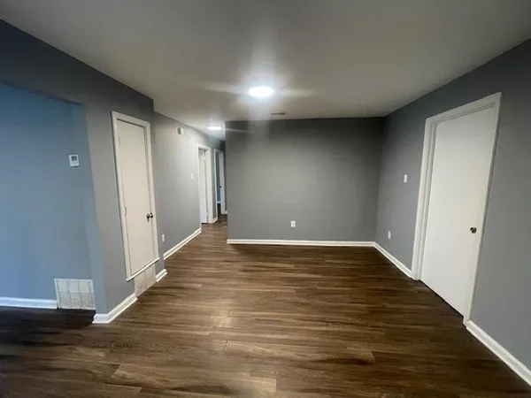 a view of an empty room with wooden floor