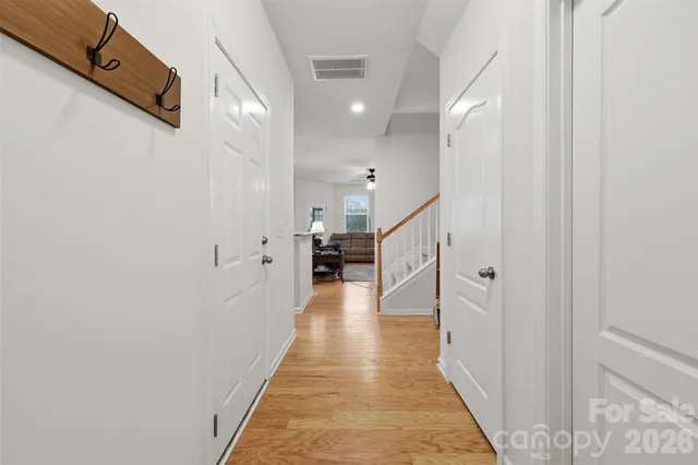 a view of a hallway with wooden floor and staircase